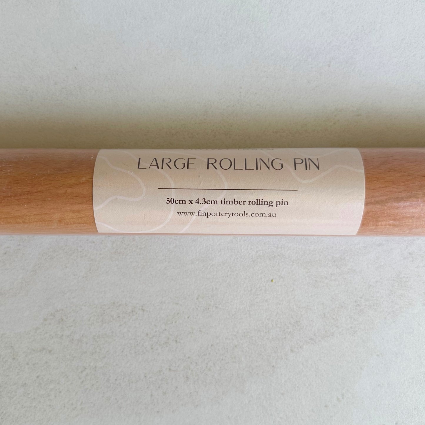 Large timber rolling pin for rolling large, even slabs of clay. Measures 50cm long and 4.3cm in diameter.
