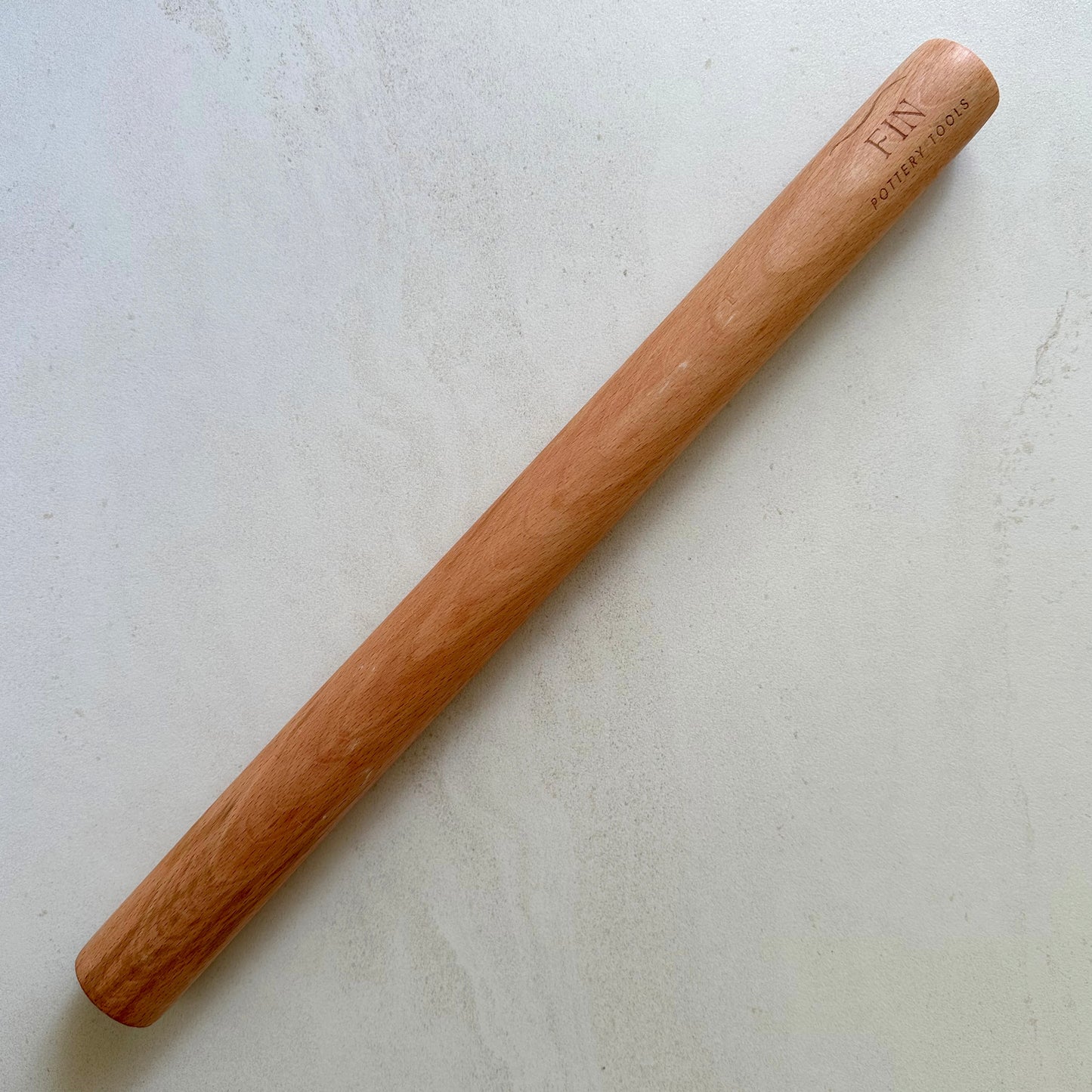 Large timber rolling pin for rolling large, even slabs of clay. Measures 50cm long and 4.3cm in diameter.