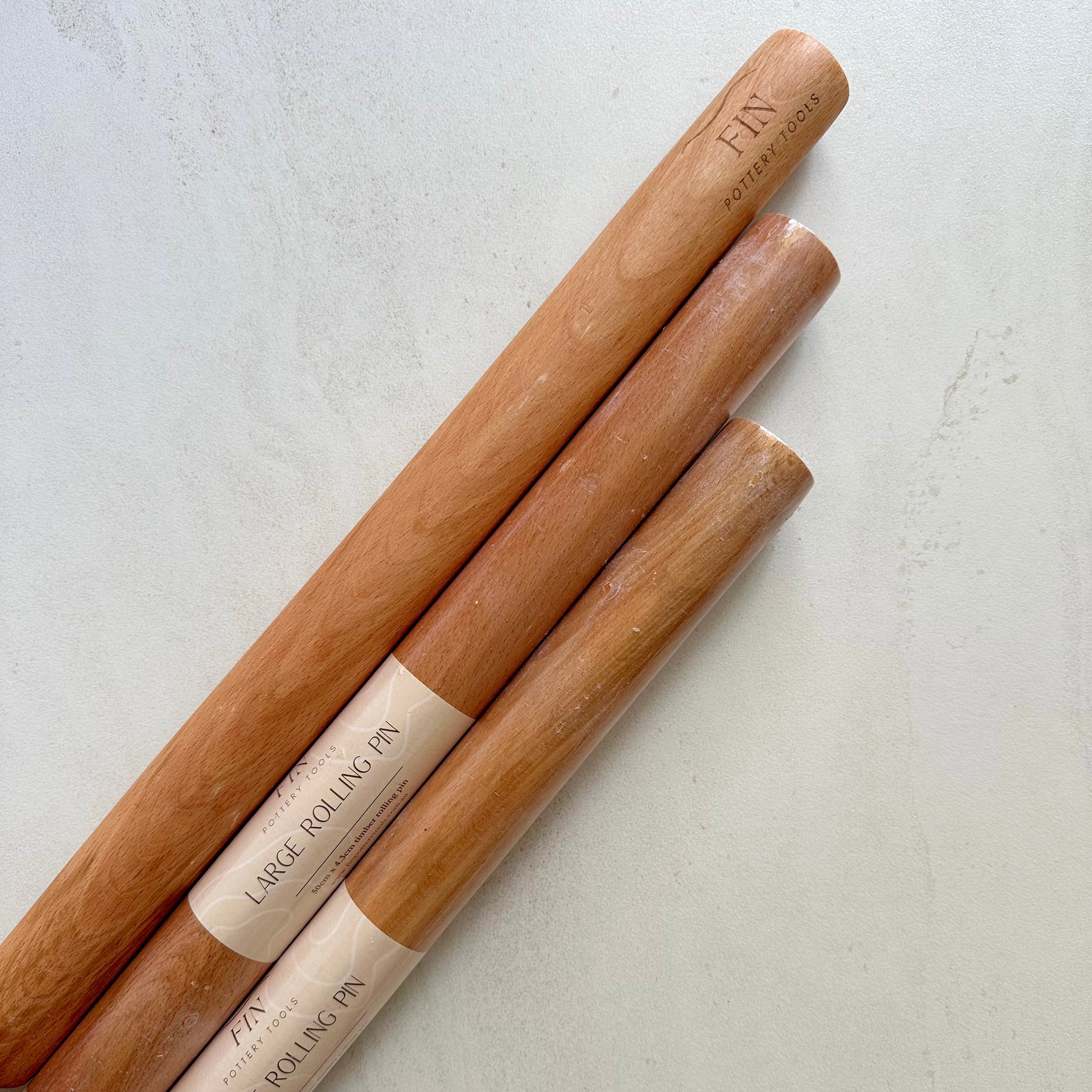 Large timber rolling pin for rolling large, even slabs of clay. Measures 50cm long and 4.3cm in diameter.