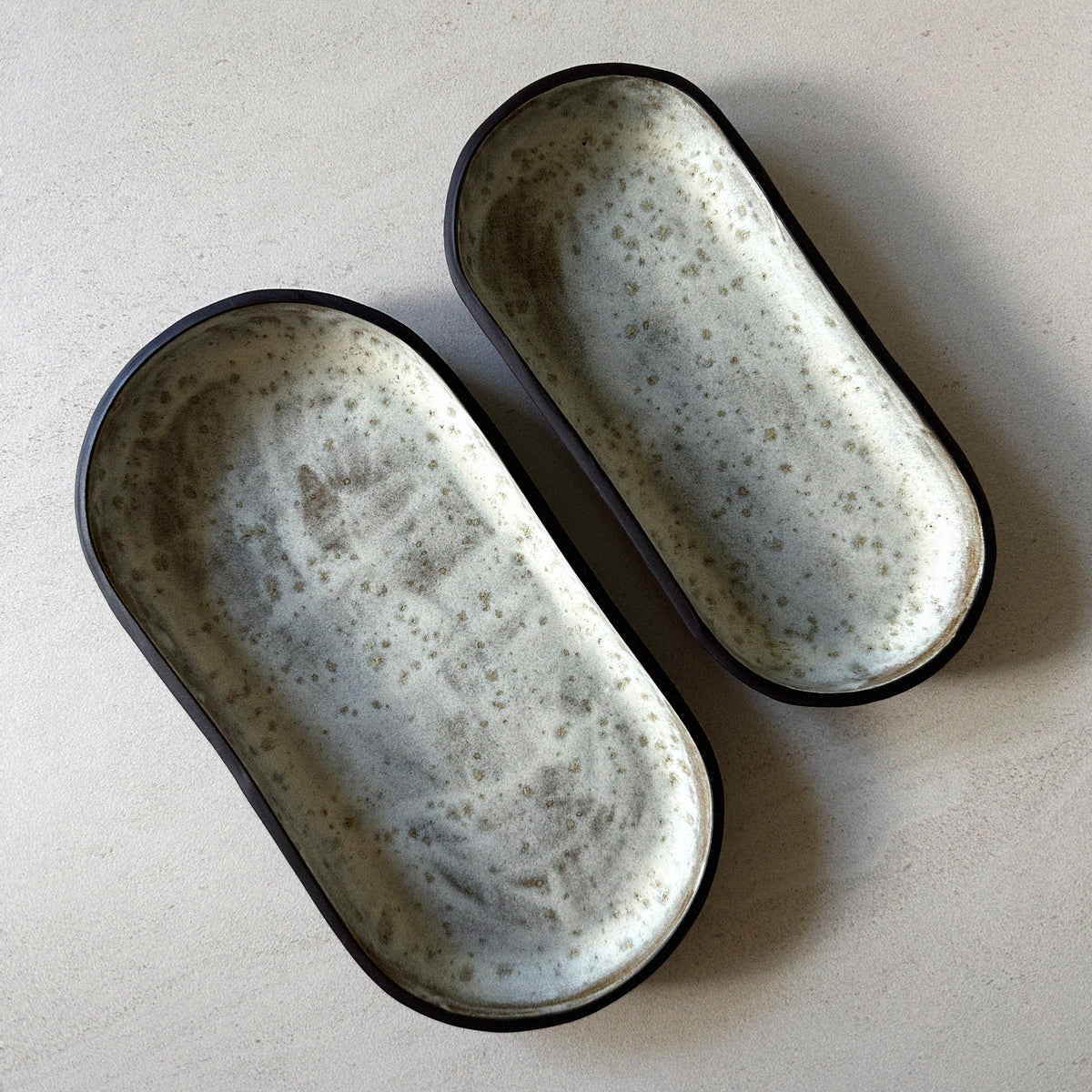 Two spotty grey-white oblong blate platters made using the Fin Pottery Tools Oblong Blate Bundle